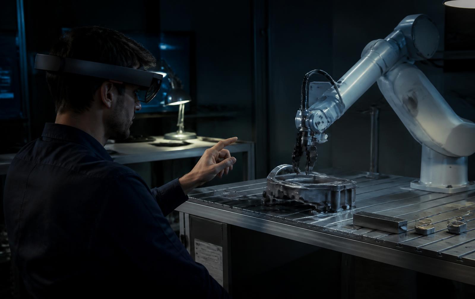An engineer wearing a spatial interface headset directing a robotic arm in a laboratory